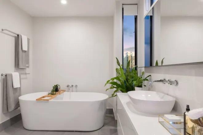 Design reference: white bathroom with a freestanding oval soaking tub, wall-mounted tub filler